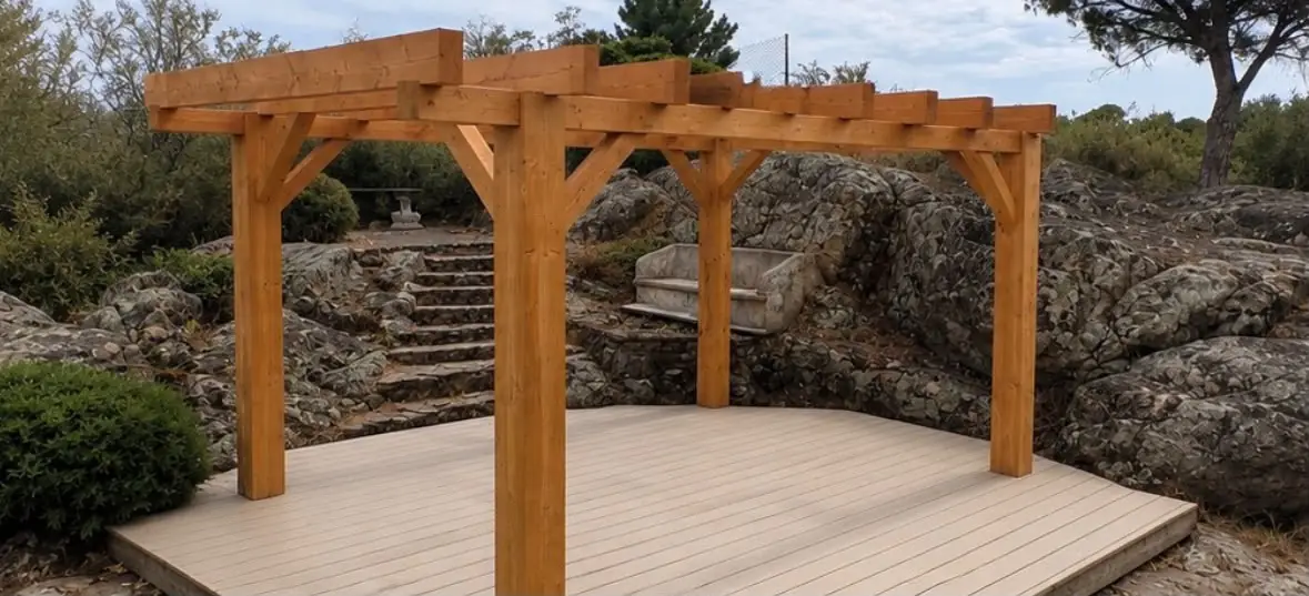 Terrasse en lames composites claires posée entre les rochers, sous une pergola en bois