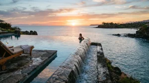 Piscine à débordement face à la mer calme, eau débordant au coucher.